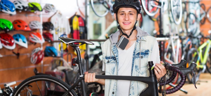 Young man holding bike with helmet