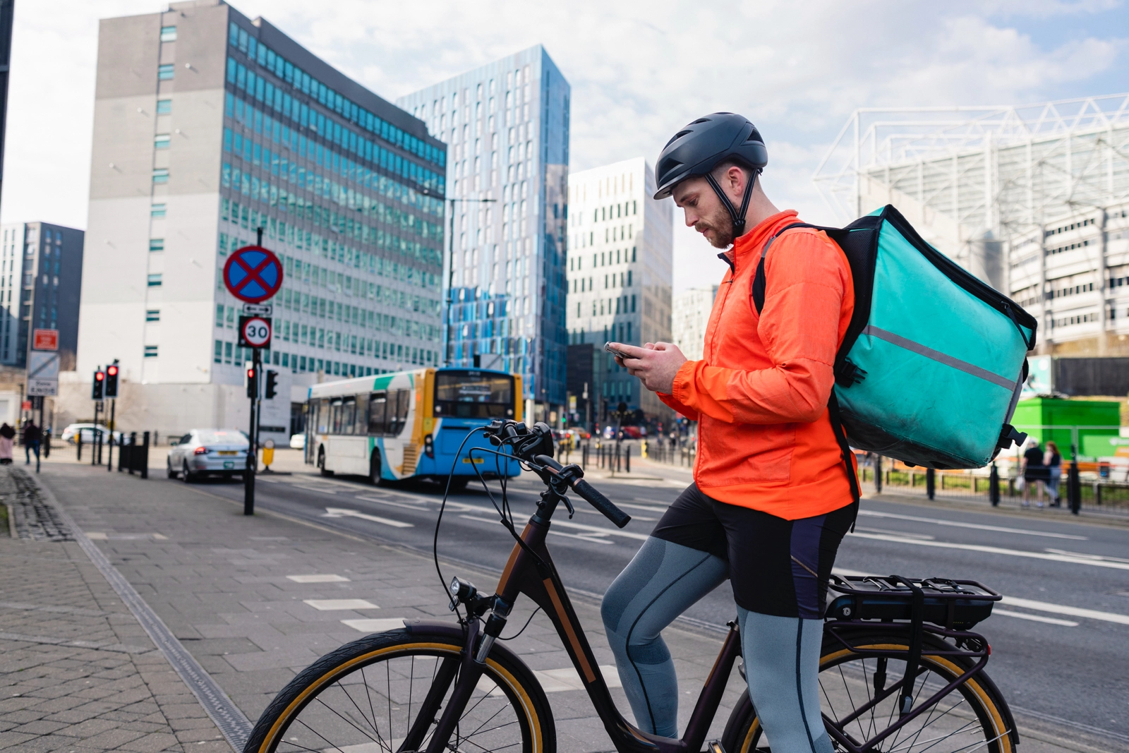 Delivery cyclist riding at night in the city.